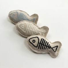 two fish shaped brooches sitting next to each other