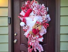 a christmas wreath with santa claus and candy canes on the front door to a house