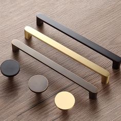 an assortment of brass and black handles on a wooden surface