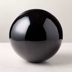 a black vase sitting on top of a white table