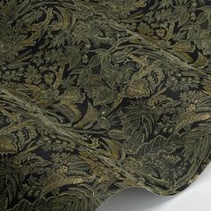 a black and gold fabric with green leaves on it