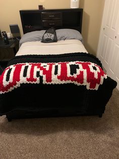 a bed with a red and white afghan on it