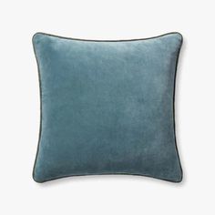 a blue velvet pillow on a white background