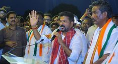 the man is giving a speech in front of a group of people with their hands up