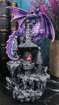 a purple dragon statue sitting on top of a table