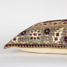 a close up of a pillow on a white surface with a flower design in the middle