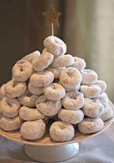 a white plate topped with donuts covered in powdered sugar