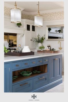 a large kitchen with blue cabinets and white counter tops is featured in the hgt magazine