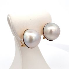 Large Round Mabe Pearl French/Omega Clip Earrings in 14k Yellow Gold  Vintage/Estate  ET1023 Add a touch of elegance to your look with these round Mabe pearl earrings. Crafted in 14k yellow gold with a French omega clip for secure and comfortable wear, these earrings feature a unique type of pearl known as a Mabe pearl. Mabe pearls are half-spherical cultured pearls that are grown against the inside of a mollusk shell rather than in the body of the mollusk itself. This process gives Mabe pearls a distinctive shape and lustrous finish. Elevate your jewelry collection with these stunning Mabe pearl earrings. Metal Content: Solid 14k Yellow Gold Gemstone: Cultured Mabe Pearl - white  Cut: Round Cabochon Approximate Size: 16mm Weight: 13.87 Grams Stamps: 14k 585 Condition: Excellent Pre-Owned Formal Briolette Earrings With High Luster, High Luster Briolette Earrings For Formal Occasions, Formal High Luster Briolette Earrings, Oval High Luster Pearl Earrings For Formal Events, Formal High Luster Oval Pearl Earrings, Formal Yellow Gold Earrings With High Luster, Formal Yellow Gold High Luster Earrings, Formal Briolette Pearl Earrings In Fine Jewelry Style, Yellow Gold Briolette Pearl Earrings For Formal Occasions