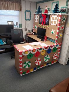 an office cubicle decorated for christmas with gingerbreads and candy canes on the desk