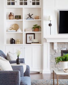 a living room filled with furniture and a flat screen tv on top of a book shelf