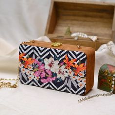 This is a beautiful printed clutch bag.It's stylish floral print with flowers makes it perfect for everyday wear.It comes with a metal sling chain. Details - Both side printed - Fabric lining on the inside to keep your belongings safe - Cushioning on printed sides - Metal lock closure - Detachable sling chain This clutch can be worn as a crossbody bag or a shoulder bag with the sling chain or can simply be carried in hand.It is spacious enough to carry mobile phones, lipsticks, Keys and other sm Trendy Rectangular Case Box Bag As Gift, Trendy Rectangular Gift Box Bag, Trendy Rectangular Box Bag As Gift, Trendy Multicolor Rectangular Box Bag, Trendy Evening Bag As A Gift, Trendy Wedding Clutch Bag, Chic Box Bag For Gift, Flower Shaped Shoulder Bag For Party, Trendy Multicolor Evening Bag