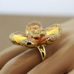 A unique flower ring featuring 5 pieces of fire opal which are used as the flower’s petals. Accenting the pieces are 1.33 carats of round brilliant cut diamonds which are set all around the ring, along with one larger fancy yellow diamond in the center. Made in 18k yellow gold.    Ring Size 7    Weight: 23.4 grams  Dimensions for this item are unknown. Please reach out with any questions on measurements. Luxury Gold Opal Ring With Diamonds, Elegant Multi-stone Diamond Flower Ring, Luxury Gold Opal Ring With Brilliant Cut, Luxury Yellow Gold Flower Ring With Gemstone, Luxury Cubic Zirconia Flower Ring, Elegant Yellow Flower-shaped Ring, Luxury Yellow Flower Shaped Jewelry, Luxury Yellow Flower-shaped Jewelry, Elegant Yellow Flower Shaped Ring