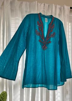 "Beautiful Summer tunic top is 100% cotton. Embellished with pink sequins on front. Lightweight and comfortable, no designer label found. Bust measures 22\" across; Waist 21\" across Side splits for easy movement. No stretch to fabric. Material is semi-sheer, can wear cami underneath" Casual Turquoise V-neck Blouse, Turquoise Cotton Beach Tops, Fitted Cotton V-neck Tunic, Long Sleeve Embellished Festive Tunic, Casual Cotton Tops With Sequins, Festive Embellished Long Sleeve Tunic, Festive Long Sleeve Embellished Tunic, Festive Cotton V-neck Top, Festive V-neck Summer Tops