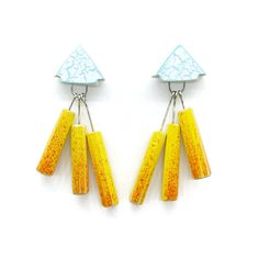 two pairs of yellow and blue earrings with dangling hooks on each earring, against a white background