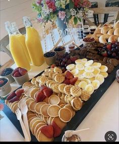 a table filled with waffles, fruit and juice