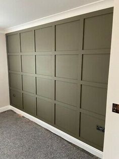 an empty room with a garage door in the center and carpet on the floor next to it