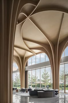 the inside of a building with large windows and curved wooden columns on either side of it