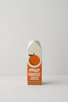 an orange juice carton on a white surface