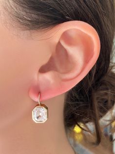 Classic setting, with a modern yet vintage vibe. Each bezel set stone, surrounded by milgrain detail, is attached to fixed wire that hangs from the earlobes beautifully. (Stone shape may vary slightly based on availability.). Offered in Colorless & Pink. 14kt Gold Each earring has a 2.5ct Premium Grade Zircon Exquisitely Handcrafted in Los Angeles Vintage Vibe, Rose Gold Earrings, White Rose Gold, Vintage Vibes, 14kt Gold, Bezel Setting, Emerald Cut, White Roses, Stone Color