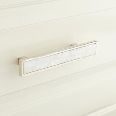 a close up of a light on a wall in a room with white paneling