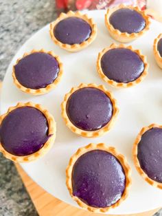 purple desserts are arranged on a white plate