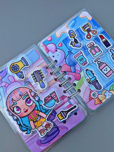 two notebooks with stickers on them sitting next to each other