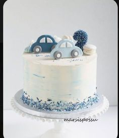 a white cake with blue frosting and cars on top