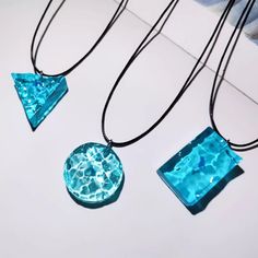 three pieces of blue glass sitting on top of a white table next to each other