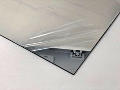 a close up of a mirror on a white surface with an object in the background