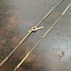 A must have chain in every jewelry collector's stash. Perfect to wear everyday on its own, or slip on one of Hilary's pendants for a gorgeously unique necklace. Hand hammered bar links are interspersed with 1.5mm cable chain. Toggle clasp. Choose from 14k gold or 18k gold. 18 inch length. Please contact Hilary for custom lengths. Made to order and will ship in 3-4 weeks. Elegant Hammered Link Chain Necklace, Elegant Hammered Link Necklace, Gold Minimalist Toggle Necklace With Cable Chain, Minimalist Toggle Necklace With Cable Chain, Gold Minimalist Bar Necklace With Satellite Chain, Modern Gold Bar Necklace With Adjustable Chain, Minimalist Yellow Gold Toggle Link Necklace, Minimalist Yellow Gold Link Toggle Necklace, Gold Minimalist Bar Necklace With Cable Chain