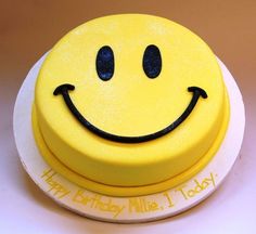 a yellow smiley face cake sitting on top of a white plate with the words happy birthday mike today