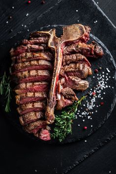 steak with herbs and seasoning on a black plate