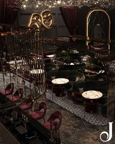 the interior of a fancy restaurant with red velvet chairs and gold chandelier hanging from the ceiling