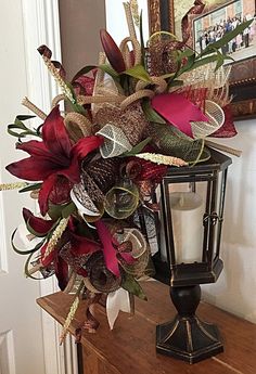 a candle is sitting on top of a wooden table next to a vase filled with flowers