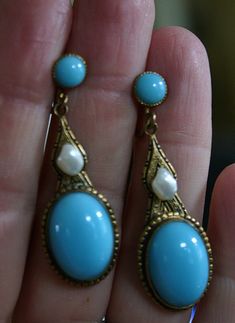 "Very fine pair of Czechoslovakian earrings from the Art Nouveau era, circa 1910. Beautifully shaped pendant earrings in gold tone appointed with French blue opaline type poured glass cabochons and glass button tops. The middle section accented with lovely natural baroque pearls. These pearls are often referred to as \"tooth\" pearls or Mississippi river pearls due to their unusual shape. The pearls are well matched and have beautiful lustrous nacre... amazing for  earrings over a hundred years Blue High Luster Earrings For Formal Occasions, Formal Blue High Luster Earrings, Antique Blue Earrings, Vintage Cabochon Dangle Earrings, Victorian Cabochon Drop Earrings, Elegant Blue Cabochon Clip-on Earrings, Vintage Blue Drop Earrings Jewelry, Victorian Blue Earrings For Formal Occasions, Blue Elegant Earrings