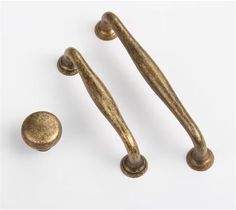 two brass handles and knobs on a white background