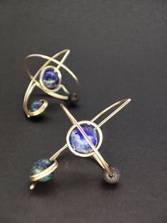 These elegant and futuristic earrings are an original design. Inspired by earths gravitational tidal lock and the three body problem. Three astral bodies in each others orbit.   Enjoy the deep vibrant colors of these gemstones against yellow gold.  These lightweight earrings are made to the golden ratio, considering proportion and negative space. Featuring a Lapis Lazuli gemstone planet, a black lava stone moon and an Azurite satellite planet. Gemstones are carefully selected for their aesthetic Nickel-free Modernist Earrings For Gift, Nickel Free Modernist Earrings For Gift, Modernist Pierced Drop Earrings, Modernist Drop Earrings, Modernist Nickel Free Earrings As Gift, Modernist Nickel-free Earrings As Gift, Modernist Nickel-free Earrings For Gift, Modernist Pierced Jewelry Gift, Modernist Pierced Jewelry For Gift