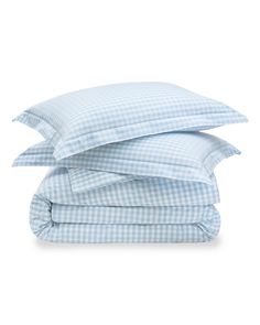 three pillows stacked on top of each other in blue and white gingham sheets