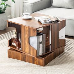 a coffee table with a magazine rack on it and a bottle of liquor in the middle