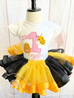 Bumble Bee Tutu Outfit, Bee Birthday Shirt, Bumble Bee Birthday Tutu Outfit, Bee Birthday party outfit, Ribbon Trim Tutu Outfit PROCESSING TIME IS 3-5 DAYS NOT INCLUDING SHIPPING. This personalized bumble bee birthday shirt is a great choice for your next bee theme birthday party outfit. This pink, yellow and black birthday outfit features the birthday number of your choice along with a super cute bumble bee embroidered onto it. This bee birthday shirt is perfect for young girls. Your little one Bee Birthday Theme, Bumble Bee Birthday, Ribbon Trim Tutu, Birthday Party Outfit, Bee Birthday Party, Birthday Tutu Outfit, Black Birthday, Bee Birthday, Birthday Party Outfits