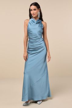 a woman in a long blue dress with high neck and side drapes on the skirt