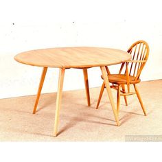 a wooden table and two chairs sitting next to each other on carpeted flooring