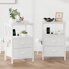 two white nightstands sitting next to each other on top of a wooden floor