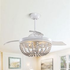 a white ceiling fan with crystal beads hanging from it's blades in a living room