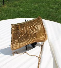 Beautiful gold mesh Evening bag/purse/handbag.  It is the same on both sides with gathering that almost looks pleated under a band across the top.  Zippered closure with gold tone metal chain handle/shoulder strap.  The inside is a light cloth lining and a zipper pocket.  Although considered and evening bag, this would be great with your favorite jeans.   It is in extremely good vintage condition, no missing metal beads or wear to note.  The inside is very clean, the strap is a little dull.   Measures:  11 inches wide at the bottom and 8 inches wide at the top x 7 inches tall (29 1/2 inches with handle/strap) Gold Pouch Clutch With Chain Strap, Gold Evening Bag With Chain Strap, Gold Chain Strap Pouch Clutch, Vintage Gold Shoulder Bag With Chain Strap, Gold Evening Bag With Chain Strap For Night Out, Gold Handheld Shoulder Bag For Night Out, Gold Handheld Clutch For Night Out, Long Chain, Metal Beads