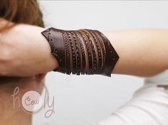 a woman wearing a brown leather bracelet on her arm