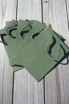 four pieces of green paper sitting on top of a wooden table next to each other