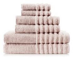 a stack of white towels sitting on top of each other in front of a white background