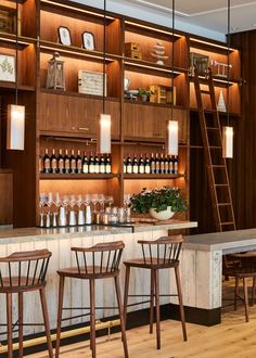 an empty bar with stools and wooden shelves